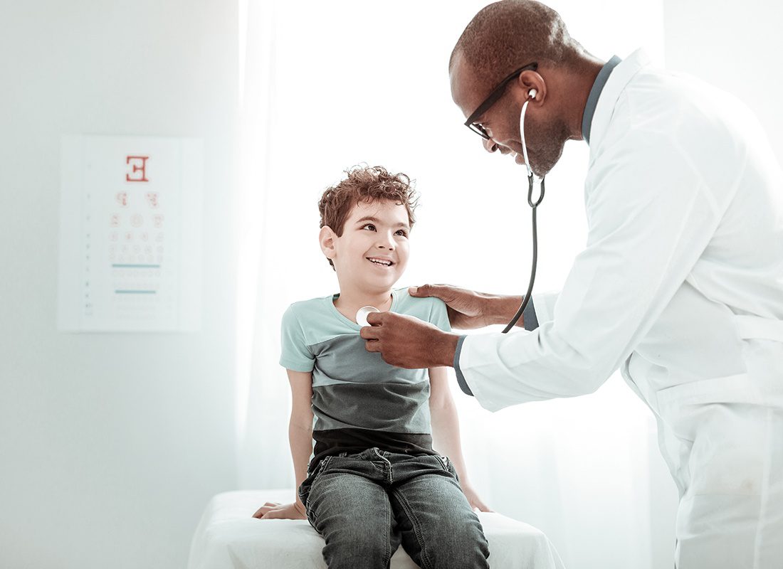 Employee Benefits - Doctor Giving a Young Boy a Check-up at a Doctor's Office